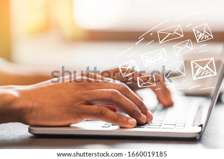 Online communication concept. African American man typing and sending e-mails in office, design with envelope icons Royalty-Free Stock Photo #1660019185