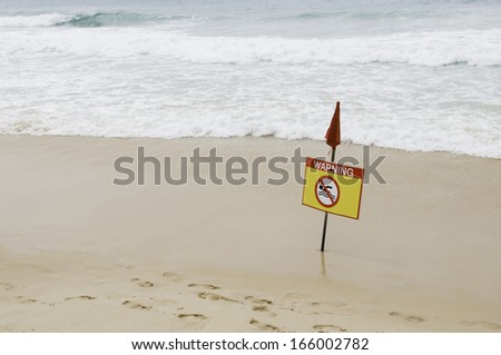 Marine yellow warning sign with a red flag.