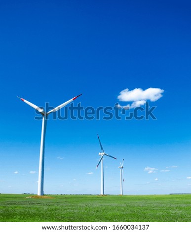 Wind turbine on green field blue sky clouds green energy concept renewable energy generator