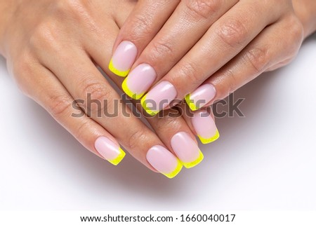 yellow french manicure, sparkles on short square nails closeup on a white background Royalty-Free Stock Photo #1660040017