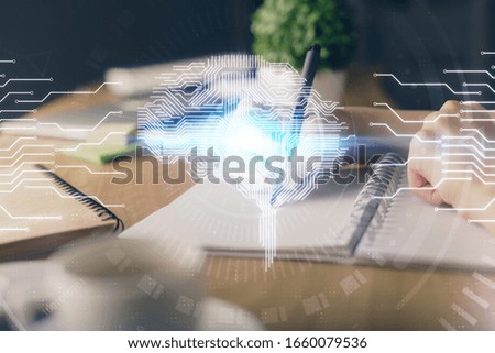 Multi exposure of writing hand on background with brain hologram. Concept of self learning.