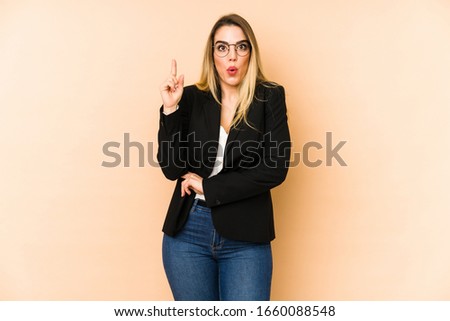 Middle age business woman isolated on beige background having some great idea, concept of creativity.