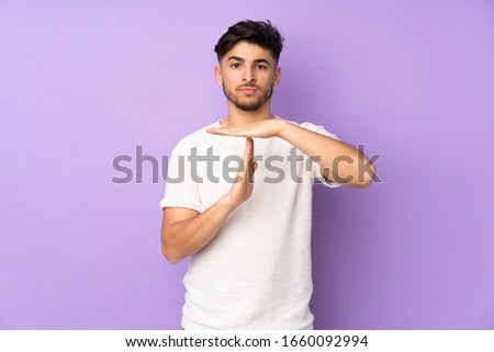 Arabian handsome man over isolated background making time out gesture