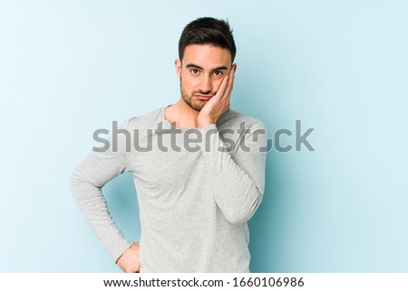 Young caucasian man isolated on blue background who feels sad and pensive, looking at copy space.