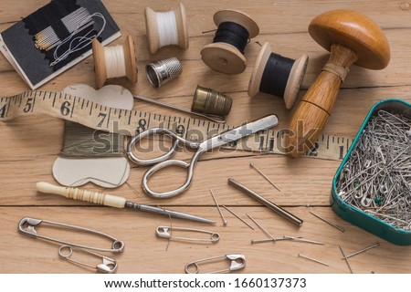 Various Haberdashery tools and equipment used for mending and repair. View from above, wooden rustic background. Royalty-Free Stock Photo #1660137373