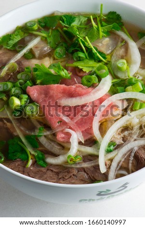 Pho soup. Vietnamese traditional classic soup made from beef stock and fresh vegetables. Soup simmered for hours and garnished with scallions, cilantro basil and bean sprouts & topped w/ a fried egg.