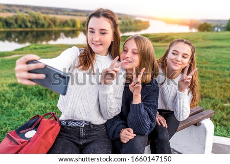 3 girls teenagers 12 13 14 years, summer , holding smartphone hands, selfie photo. Holiday weekend, best friends, emotions of happiness fun smile. Social networks on Internet, online application
