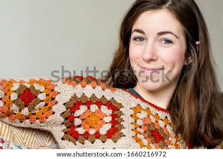 A beautiful young woman wearing a home made crochet jersey jumper and a lovely smile and green eyes Royalty-Free Stock Photo #1660216972