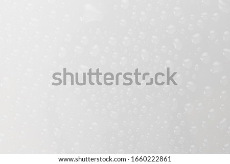 Water drops on glossy glass surface texture abstract background