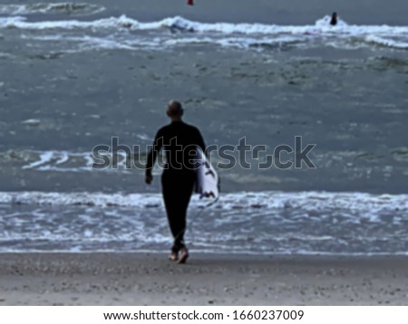 Stormy sea. Surfer getting ready. Blurred view