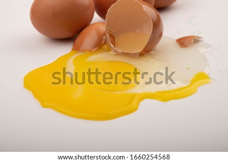 Broken chicken egg and eggs on a white background. Close up.