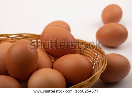 Chicken eggs in a wicker basket on a white background. Close up.