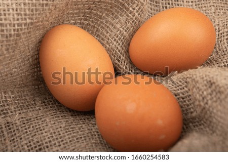 Chicken eggs on a background of rough homespun fabric. Close up.