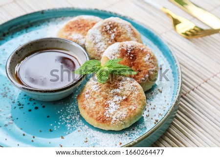 Vegan tofu cheese pancakes on blue plate with honey closeup