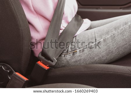 human belted by safety belt in car close-up