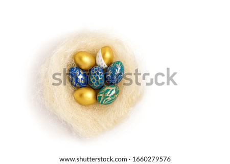 Bright painted Easter eggs in a nest on a white background, top view