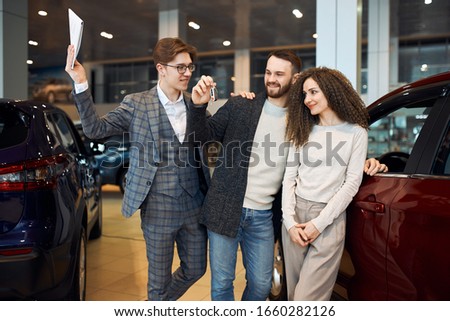 smiling young people cannot believe in their success, close up photo. couple rejoicing at new car. present, gift.