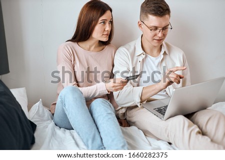 young couple booking hotel, buying tickets for travel, trip, planning holiday, booking table, room , close up side view photo
