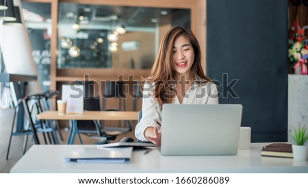 Charming asian businesswoman sitting working on laptop in office. Royalty-Free Stock Photo #1660286089
