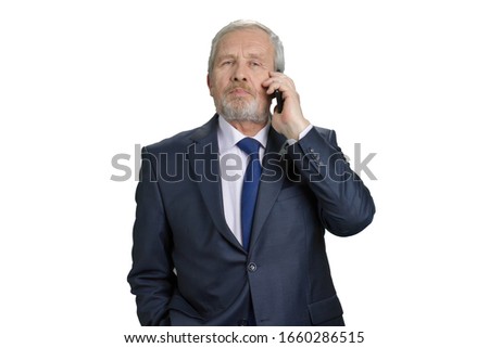 Portrait of old businessman talking on phone. Fashionable blue business suit with tie. White isolated background.