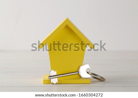 Home purchase concept. Small decorative house and keys on a white background
