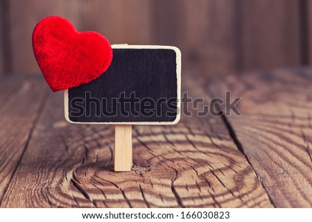 blackboard with red heart on wooden background