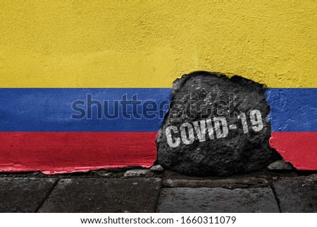 Flag of Colombia on the wall with cracked stone with Coronavirus name on it. 2019 - 2020 Novel Coronavirus (2019-nCoV) concept, for an outbreak occurs in Colombia.