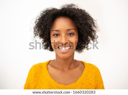 Close up front portrait smiling young african american woman with curly hair by isolated white background