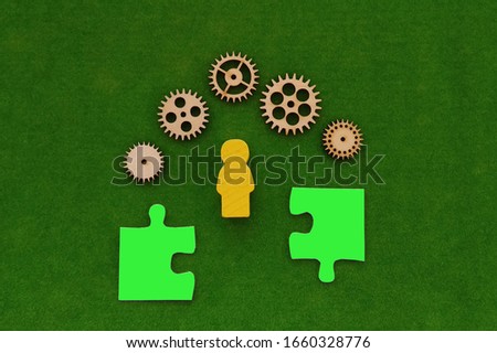 silhouette of a man, gears, puzzles in green on a green background. thinking of a business idea.