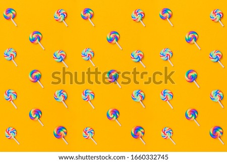 Lollipops are in a row. spiral candy pattern. lots of sweets on a yellow background. festive decoration with candies