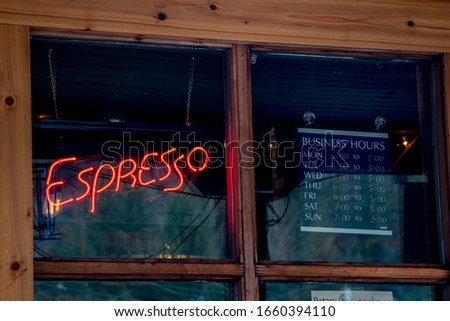 Red Neon Expresso Light from the window with the business hours sign in the other