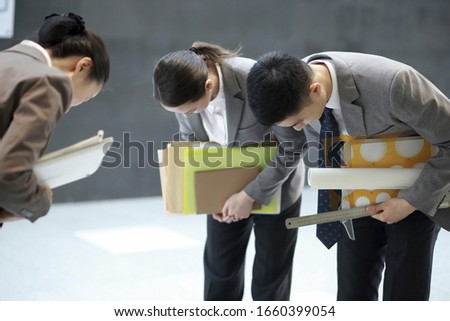 Business people taking bow in corridor Royalty-Free Stock Photo #1660399054