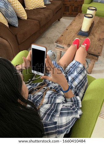 Young latin woman with mobile phone in her house, Panama, Central America