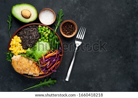 Bowl Buddha.Quinoa, chicken
breast, avocado, red cabbage, arugula, carrot, green
 peas, corn, broccoli, green beans in a plate on a stone background, with copy space for your text