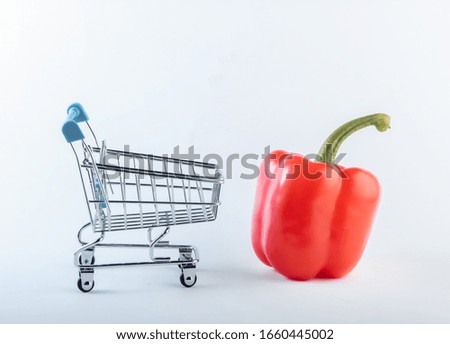 Mini Shopping trolley with red bell pepper on a white background. Supermarket concept