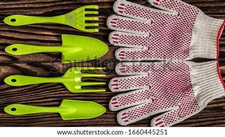 Gardening Tools concept. Gardening Gloves, Spade and fork on Wooden background with space for text flat lay top view. 