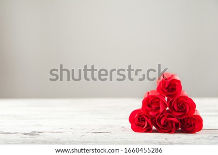 Red textured roses close-up and copy space. Womens day, mother's day, red roses on a white wooden background.