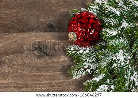festive decoration red christmas ball with pine branches over rustic wooden background