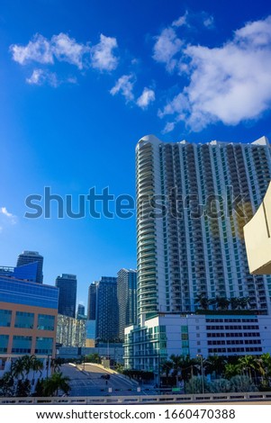 Downtown Miami cityscape view with condos and office buildings against blue sky.