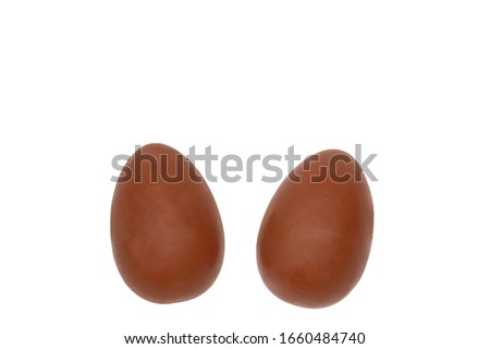 Chocolate easter eggs isolated on white background. The halves of the eggs are like the ears of a hare. Bunny rabbit dessert, top view, horizontal picture