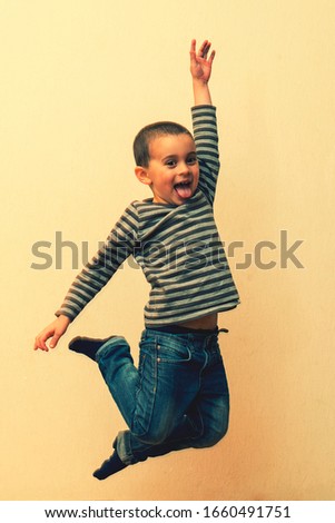 boy laying in the house. children playing at home. jumping children. vertical photo