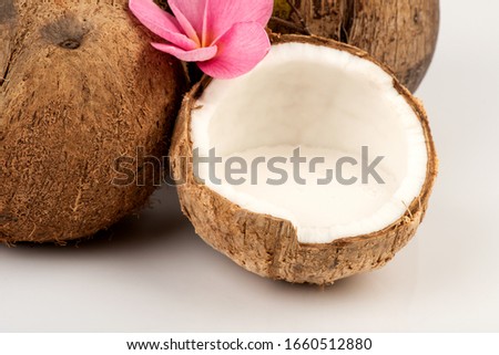 Whole coconut and half of coconut and coconut milk on white background.
