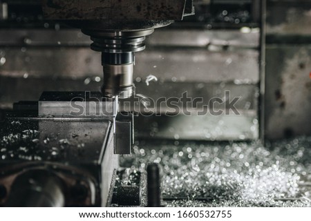 cnc machine at work at a very visibly used machine. shaping the cube of metal into usable part. close up Royalty-Free Stock Photo #1660532755