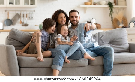 Smiling young family with little preschooler kids sit on couch in kitchen make self-portrait picture on cell together, happy parents with small children have fun take selfie on smartphone at home Royalty-Free Stock Photo #1660545964