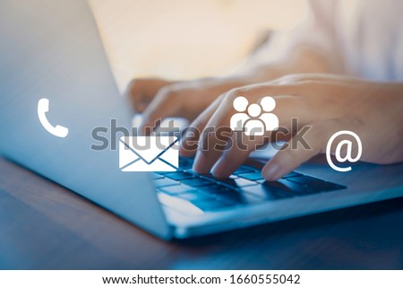 Contact us or Customer support hotline people connect. Businessman using a laptop with the (email, call phone, mail) icons. Royalty-Free Stock Photo #1660555042