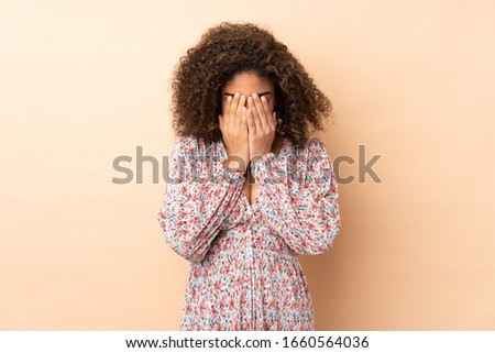 Young African American woman isolated on beige background with tired and sick expression