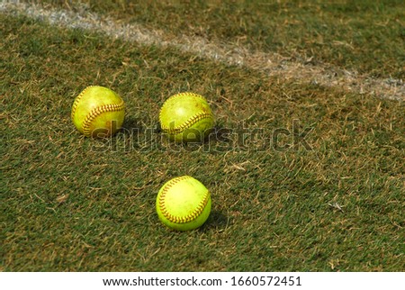 neon green softballs on green grass