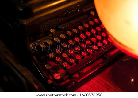 letters on the typewriter illuminated by a lamp
