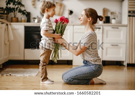 happy mother's day! child son congratulates mother on holiday and gives flowers
