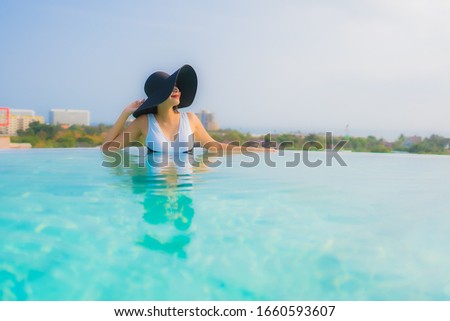 Portrait beautiful young asian woman happy smile relax around outdoor swimming pool in hotel resort for travel vacation